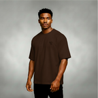 Man wearing a brown t-shirt with a logo on a gray background