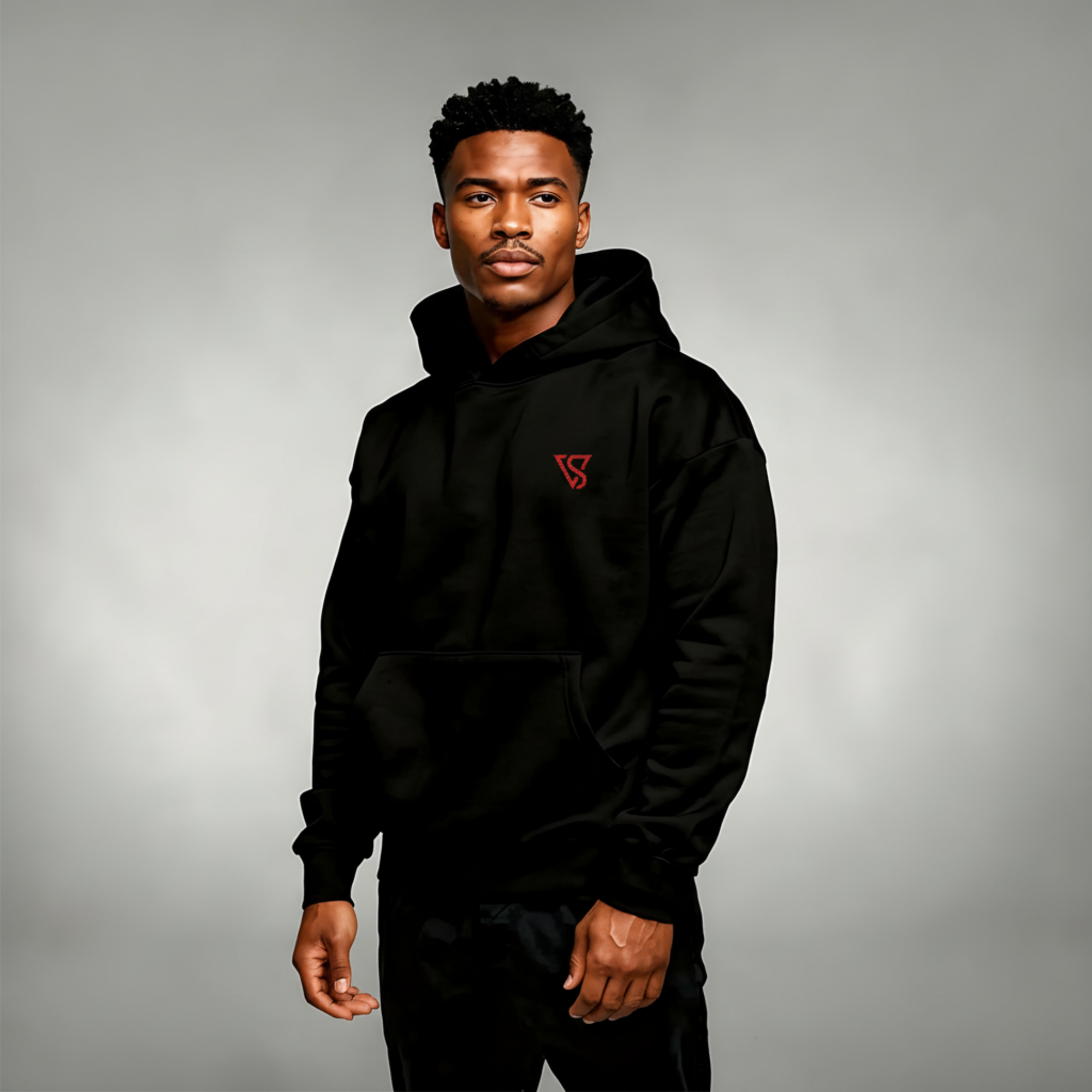 Man wearing a black hoodie with a red logo on a gray background