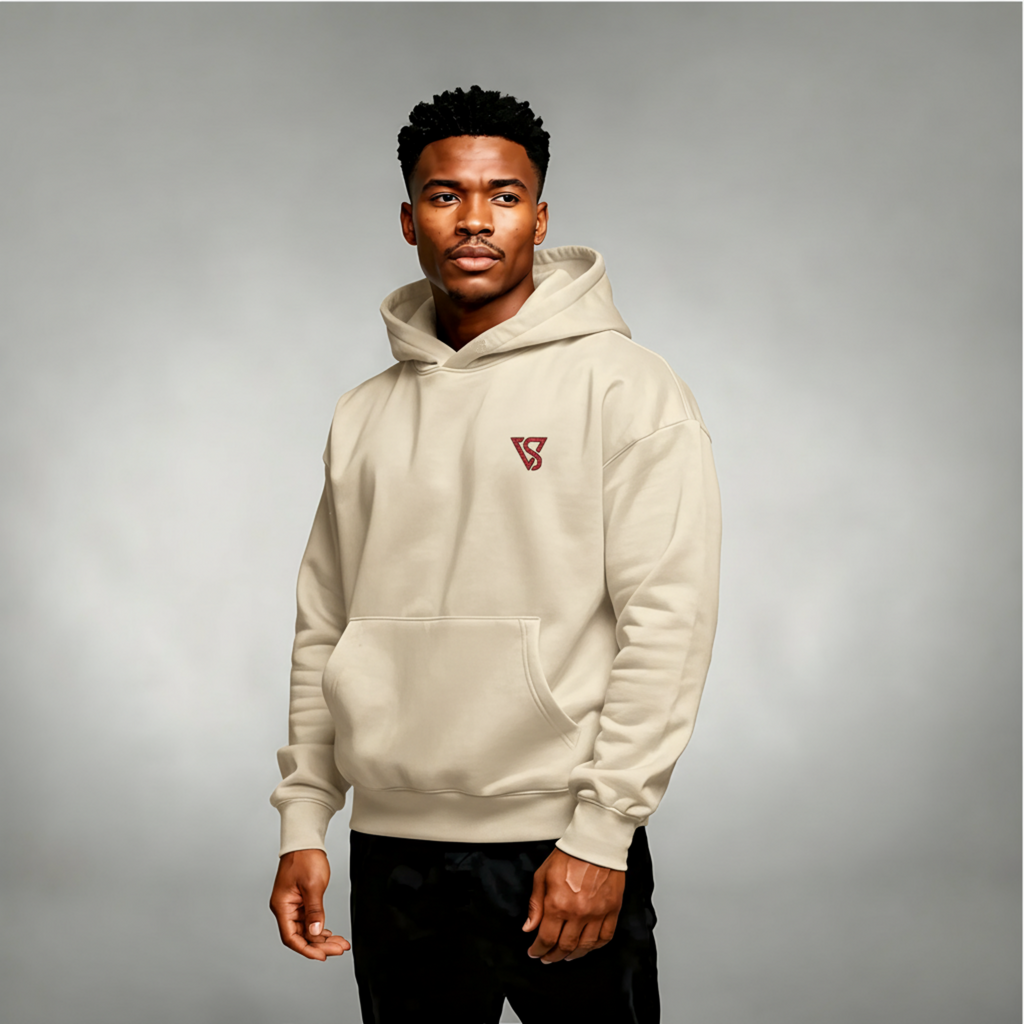 Man wearing a beige hoodie with a logo on a gray background