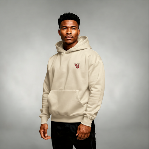 Man wearing a beige hoodie with a logo on a gray background