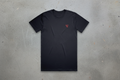 Black t-shirt with a red logo on a conrete background