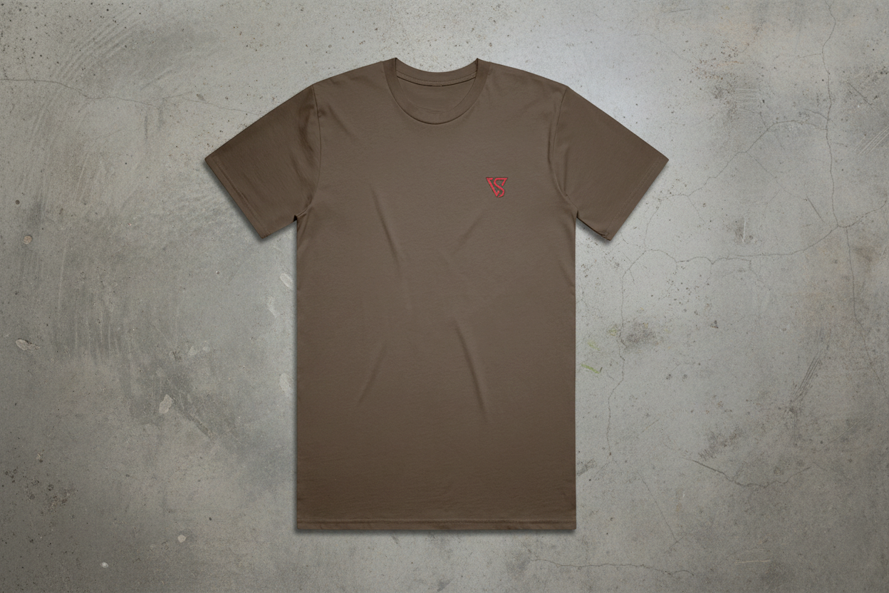 Brown t-shirt with a small red logo on a concrete background