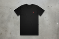 Black t-shirt with a red logo on a concrete background