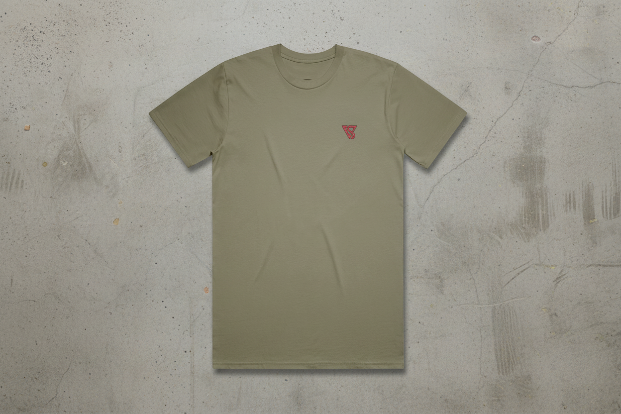 Olive green t-shirt with a small red logo on a concrete background
